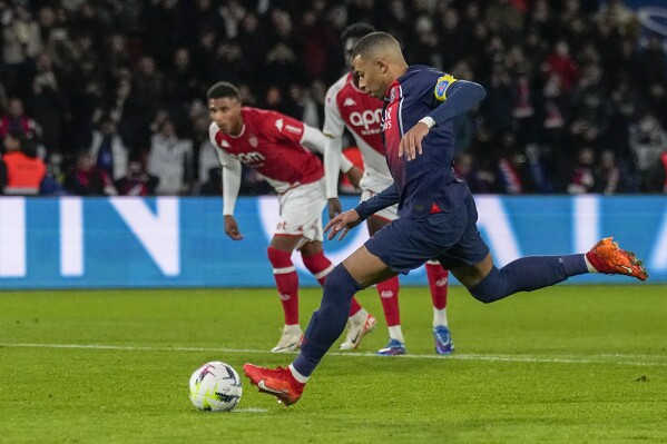 PSG's Kylian Mbappe scores his side's second goal from penalty spot during the French League One soccer match between Paris Saint-Germain and Monaco, at the Parc des Princes stadium in Paris, France, Friday, Nov. 24, 2023. (AP Photo/Michel Euler)
