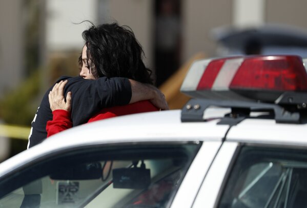 
              Heidi Fleiss, right, embraces an unknown person outside of the Love Ranch brothel, Tuesday, Oct. 16, 2018, in Pahrump, Nev., where Nevada brothel owner Dennis Hof died. (AP Photo/John Locher)
            