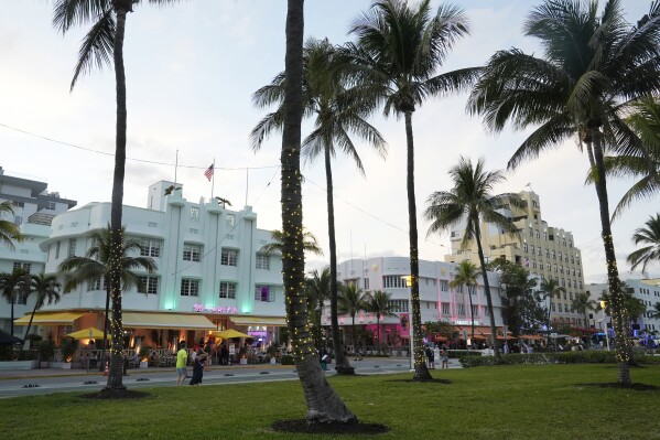 Pedestrians walk along Ocean Drive with its beautiful Art Deco buildings, Tuesday, Feb. 27, 2024, in Miami Beach, Fla. Miami Beach officials are implementing a series of measures to discourage non residents from going to South Beach for spring break. They include curfews, DUI checkpoints and closing parking garages. (AP Photo/Marta Lavandier)