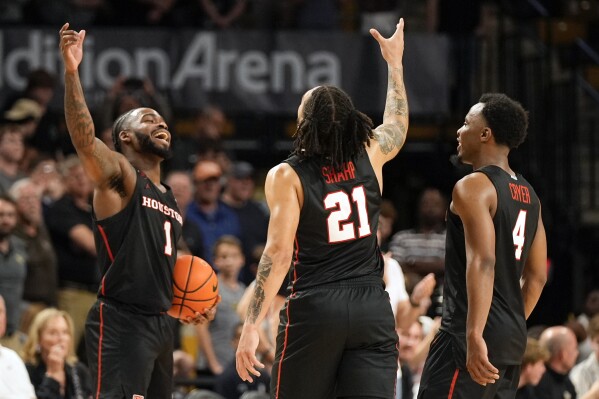 Houston guard Jamal Shead (1), guard Emanuel Sharp (21) and guard L.J. Cryer (4) celebrate the team's win over Central Florida in an NCAA college basketball game Wednesday, March 6, 2024, in Orlando, Fla. (AP Photo/John Raoux)