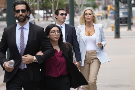 FILE - The son, left, and daughter, back right, of Pittsburgh dentist Lawrence "Larry" Rudolph head into federal court for the afternoon session of the trial, July 13, 2022, in Denver. Rudolph accused of shooting and killing his wife in their cabin at the end of an African safari trip has denied that he killed her. Rudolph took the stand Wednesday, July 27, 2022, at his murder trial in Denver federal court. (AP Photo/David Zalubowski, File)