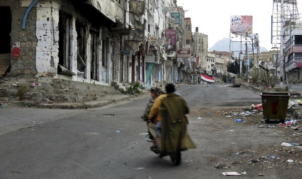 
              Men ride through streets wrecked by fighting in Taiz, Yemen in this Feb. 4, 2018, photo. The city gives the clearest example of the intertwining of al-Qaida with militias funded by the U.S.-backed coalition to fight the Houthi rebels. Al-Qaida militants are among the fiercest fighters in the city, driving the rebels out of some areas, and militia commanders have close ties to and recruit from the group. (AP Photo)
            