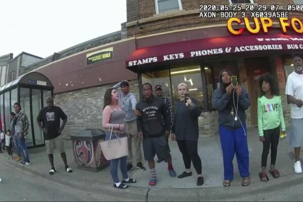 FILE - In this image from a police body camera, bystanders including Alyssa Funari, left filming, Charles McMillan, center left in light colored shorts, Christopher Martin center in gray, Donald Williams, center in black, Genevieve Hansen, fourth from right filming, Darnella Frazier, third from right filming, witness as then Minneapolis police officer Derek Chauvin pressed his knee on George Floyd's neck for several minutes, killing Floyd on May 25, 2020 in Minneapolis. (Minneapolis Police Department via AP, File)