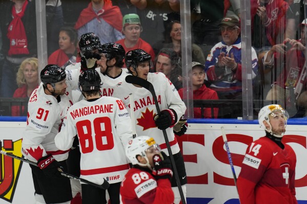 Canada's Dylan Cozens celebrates with teammates after scoring his sides second goal during the preliminary round match between Canada and Switzerland at the Ice Hockey World Championships in Prague, Czech Republic, Sunday, May 19, 2024. (AP Photo/Petr David Josek)