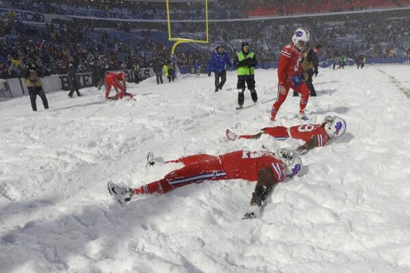 FILE - Buffalo Bills players make snow angels in the snow after defeating the Indianapolis Colts after an NFL football game, on Sunday, Dec. 10, 2017, in Orchard Park, N.Y. The NFL is monitoring the weather and has contingency plans in place in the event a lake-effect snowstorm hitting the Buffalo disrupts the Bills ability to host the Cleveland Browns on Sunday, Nov. 20, 2022. (AP Photo/Adrian Kraus, File)