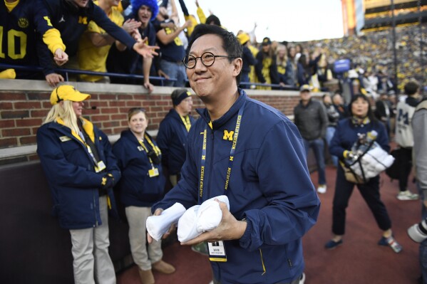 University of Michigan President Santa Ono prepares to throw his t-shirt into the crowd in Ann Arbor, Michigan on Saturday, November 2, 2024, in Ann Arbor, Michigan, late in the NCAA college football game against Oregon (AP Photo/Jose Juarez)