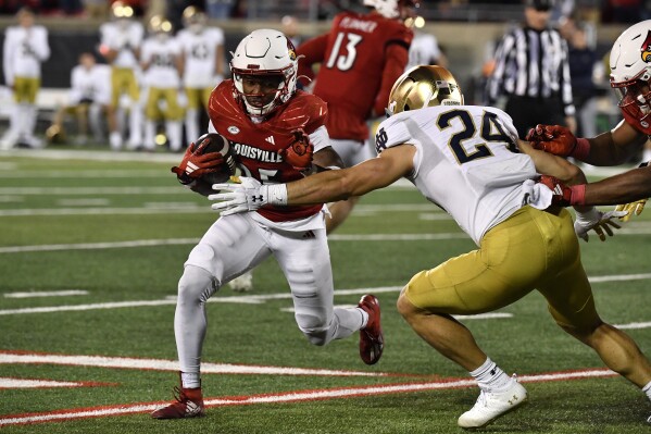 Notre Dame linebacker Jack Kiser (24) attempts to bring down Louisville running back Jawhar Jordan (25) during the second half of an NCAA college football game in Louisville, Ky., Saturday, Oct. 7, 2023. (AP Photo/Timothy D. Easley)