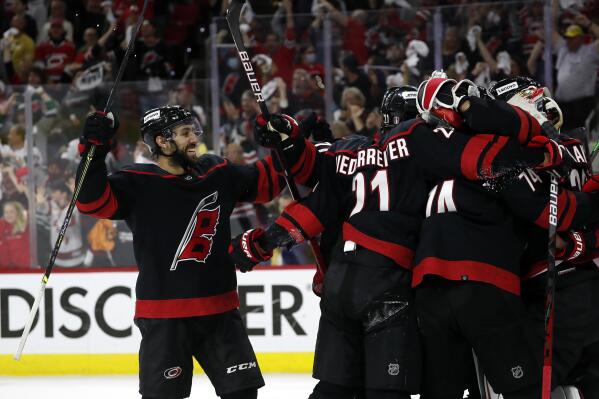 Carolina Hurricanes' Vincent Trocheck (16) joins the celebration around goaltender Antti Raanta following their win over the Boston Bruins in Game 7 of an NHL hockey Stanley Cup first-round playoff series in Raleigh, N.C., Saturday, May 14, 2022. (AP Photo/Karl B DeBlaker)