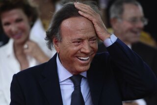 FILE - In this Sept. 29, 2016 file photo, Spain's singer Julio Iglesias smiles during his star unveiling ceremony at the Walk of Fame in San Juan, Puerto Rico. At 75 and after a five-decade-long career, Julio Iglesias keeps performing internationally, driven by his passion and, above all, a relentless discipline. It’s something the Spanish crooner says he had to learn early on, after a nearly fatal car accident frustrated his plans to play professional soccer. (AP Photo/Carlos Giusti, File)