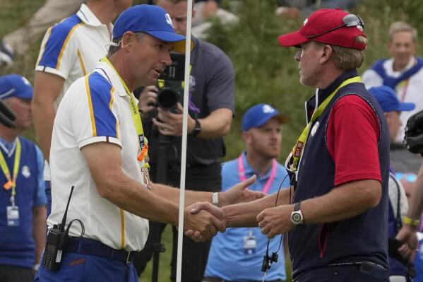 Team USA captain Steve Stricker shakes hands with Team Europe captain Padraig Harrington after the Ryder Cup matches at the Whistling Straits Golf Course Sunday, Sept. 26, 2021, in Sheboygan, Wis. (AP Photo/Charlie Neibergall)