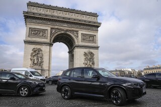 FILE - SUV car drive on the Champs Elysees avenue, near to the Arc de Triomphe Wednesday, Jan. 31, 2024 in Paris. Paris residents are voting on Sunday, Feb. 4, 2024 whether to muscle SUVs off the French capital’s streets by making them much more expensive to park. It's the latest leg in a drive by Socialist Mayor Anne Hidalgo to make the host city for this year’s Olympic Games greener and friendlier for pedestrians and cyclists. (AP Photo/Michel Euler, File)