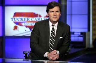 FILE - In this March 2, 2017 file photo, Tucker Carlson, host of "Tucker Carlson Tonight," poses for photos in a Fox News Channel studio, in New York. Carlson, who on Monday's show addressed the story of his former top writer, Blake Neff, who resigned after CNN found he had written a series of controversial tweets under a pseudonym, has left for vacation. It fits a pattern at Fox, whose personalities tend to go away to cool off when the heat is on. Carlson's vacation is the sixth example in a little more than three years. A Fox representative confirmed Carlson's vacation was planned before the Neff story broke. (AP Photo/Richard Drew, File)