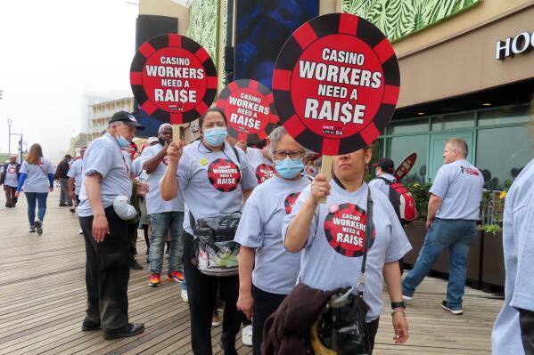 Members of Local 54 of the Unite Here union picket outside the Tropicana casino in Atlantic City, N.J., on June 1, 2022. The union was negotiating with the owners of Tropicana and two other casinos on Wednesday, June 29, 2022, trying to head off a threatened Friday strike if a new contract cannot be reached by then. (AP Photo/Wayne Parry)