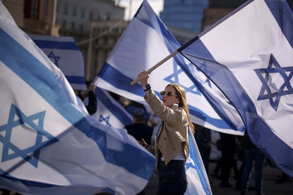 FILE - A woman holds an Israeli flag during a rally in solidarity with Israel and those held hostage by Hamas in Gaza in Bucharest, Romania on Nov. 12, 2023. (AP Photo/Andreea Alexandru, File)