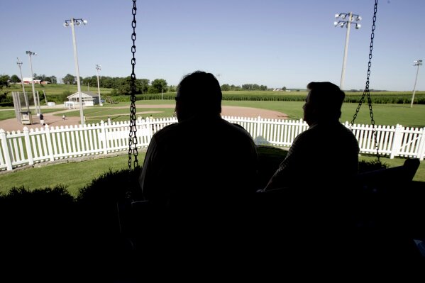 FILE - In this July 11, 2007, file photo, New Mexico Gov. Bill Richardson, left, at the time a candidate for the Democratic presidential nomination, sits on the front porch of the house at the "Field of Dreams" movie site during a campaign stop in Dyersville, Iowa. The Chicago White Sox will play a game against the New York Yankees next August at the site in Iowa where the movie "Field of Dreams" was filmed. Major League Baseball announced Thursday, Aug. 8, 2019, that the White Sox will play host to the Yankees in Dyersville, Iowa, on Aug. 13. . (AP Photo/Charlie Neibergall, File)