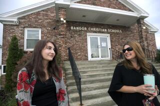 Former Bangor Christian Schools sophomore Olivia Carson, then 15, of Glenburn, Maine, left, stands with her mother Amy while getting dropped off on the first day of school on August 28, 2018 in Bangor, Maine. Parents of students enrolled in religious schools fought for years — all the way to the Supreme Court — for tuition to be reimbursed by the state, the same as other private schools. But only one religious school has signed up to participate so far. (Gabor Degre/The Bangor Daily News via AP, File)