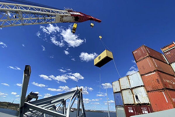 In this photo provided by the Key Bridge Response 2024 Unified Command, response crews begin removing shipping containers from the deck of the cargo ship Dali using a floating crane barge at the site of the Francis Scott Key Bridge, Sunday, April 7, 2024, in Baltimore. (Key Bridge Response 2024 Unified Command via AP)