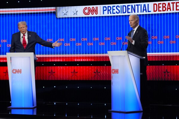 Republican presidential candidate former President Donald Trump, left, and President Joe Biden, right, speak simultaneously during a presidential debate hosted by CNN, Thursday, June 27, 2024, in Atlanta. (AP Photo/Gerald Herbert)