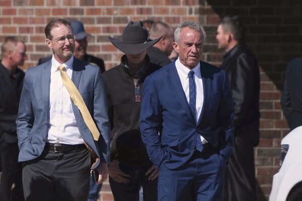 Health and Human Services Secretary Robert F. Kennedy Jr., right, arrives at Reinlander Mennonite Church in Seminole, Texas, on Sunday, April 6, 2025, after a second measles-related death in the state. (AP Photo/Annie Rice, File)