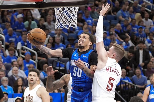 Orlando Magic guard Cole Anthony (50) makes a shot as he gets past Cleveland Cavaliers guard Sam Merrill (5) during the second half of Game 3 of an NBA basketball first-round playoff series Thursday, April 25, 2024, in Orlando, Fla. (AP Photo/John Raoux)