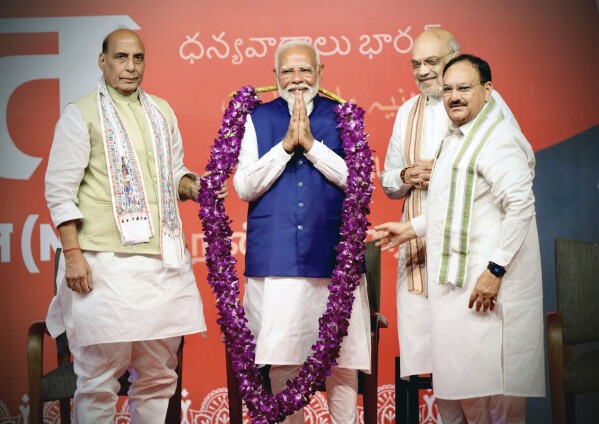 Prime Minister Narendra Modi is garlanded by senior Bharatiya Janata Party (BJP) leaders Rajnath Singh, left, party President JP Nadda, right, and Amit Shah, at the party headquarters in New Delhi, India, Tuesday, June 4, 2024. (AP Photo/Manish Swarup)