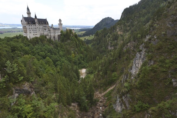 FILE - A view of the Pollat gorge with the Neuschwanstein castle, in background in Schwangau, Germany, June 16, 2023. An American man has been charged with murder and other offenses for attacking two women from the U.S. near Neuschwanstein castle in Germany in June and pushing them into a ravine, fatally injuring one of them, prosecutors said Thursday Oct. 26, 2023. (Karl-Josef Hildenbrand/dpa via AP, File)