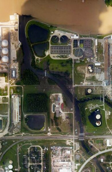 
              This handout aerial photo from the National Oceanic and Atmospheric Administration shows floodwaters surrounding the U.S. Oil Recovery Superfund site outside Houston flowing into the San Jacinto River.  The Environmental Protection Agency says it has found no evidence that toxins washed off the site, but is still assessing damage. (National Oceanic and Atmospheric Administration via AP)
            