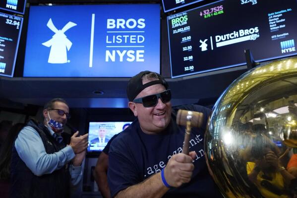 CORRECTS TITLE TO EXECUTIVE CHAIRMAN, NOT PRESIDENT - Dutch Bros Coffee Co-founder and Executive Chairman Travis Boersma rings the ceremonial first trade bell on the floor of the New York Stock Exchange, as his company's IPO opens, Wednesday, Sept. 15, 2021. (AP Photo/Richard Drew)