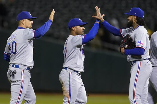 Texas Rangers' Nathaniel Lowe, left, celebrates with Andy Ibanez and Dennis Santana, right, after the Rangers defeated the Oakland Athletics in a baseball game in Oakland, Calif., Friday, May 27, 2022. (AP Photo/Jeff Chiu)