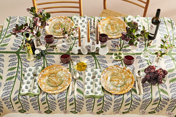 This image provided by REAL SIMPLE magazine shows a variety of colors and patterns in the linens and dishware to lend an artistic flare to a holiday table. (Murray Hall/REAL SIMPLE via AP)