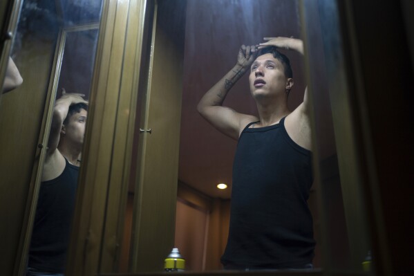 News anchor Guillermo Barraza combs his hair as he gets ready to go to work, at his home in Mexico City, Wednesday, Oct. 11, 2023. (AP Photo/Aurea Del Rosario)