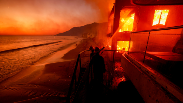 The Palisades Fire ravages a neighborhood amid high winds in the Pacific Palisades neighborhood of Los Angeles, Wednesday, Jan. 8, 2025. (AP Photo/Damian Dovarganes)