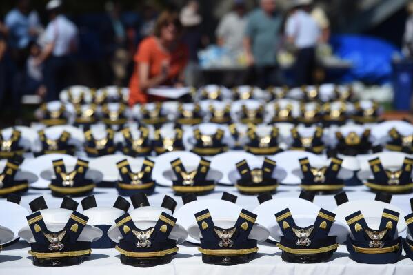 FILE - The new hats and shoulder bars for the graduates sit on a table before the start of the U.S. Coast Guard Academy's 141st Commencement Exercises, May 18, 2022, in New London, Conn. A U.S. Coast Guard Academy cadet who was expelled for becoming a father will get his degree as part of a legal settlement, his attorneys said Thursday, Oct. 6, 2022. (AP Photo/Stephen Dunn, File)