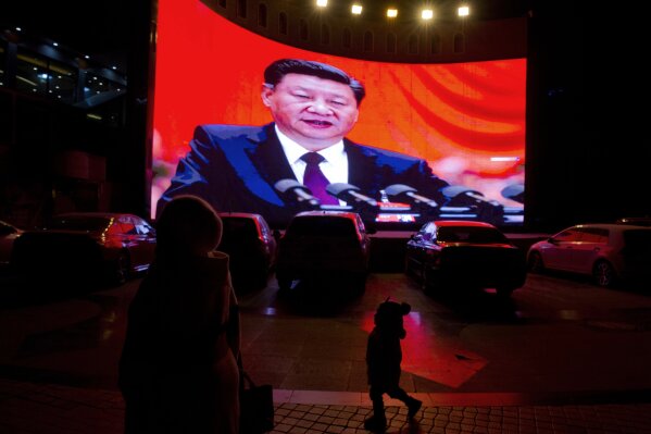 FILE.- In this Dec. 3, 2018, file photo, a child walks past a large screen showing Chinese President Xi Jinping near a carpark in Kashgar, western China's Xinjiang region. Across the Xinjiang region, a growing number of internment camps have been built, where by some estimates 1 million Muslims have been detained, forced to give up their language and their religion and subjected to political indoctrination. Confidential documents, leaked to a consortium of news organizations, lay out the Chinese government's deliberate strategy to lock up ethnic minorities to rewire their thoughts and even the language they speak.(AP Photo/File)