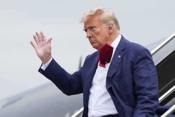 ARCHIVO - El expresidente Donald Trump saluda mientras baja de su avión en el Aeropuerto Nacional Ronald Reagan de Washington, el 3 de agosto de 2023, en Arlington, Virginia. Una pequeña mayoría de estadounidenses aprueba que el Departamento de Justicia de Estados Unidos acuse a Trump por sus esfuerzos por permanecer en cargo después de perder las elecciones de 2020, según una nueva encuesta de The Associated Press-NORC Center for Public Affairs Research.  (Foto AP/Alex Brandon, archivo)