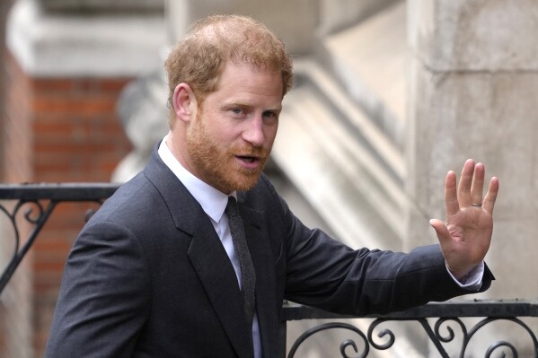 FILE - Britain's Prince Harry salutes media as he arrives at the Royal Courts of Justice in London, on March 30, 2023. Prince Harry is expected to return to the U.K. next month to attend a charity awards ceremony on the eve of the first anniversary of Queen Elizabeth II’s death. (AP Photo/Kirsty Wigglesworth, File)
