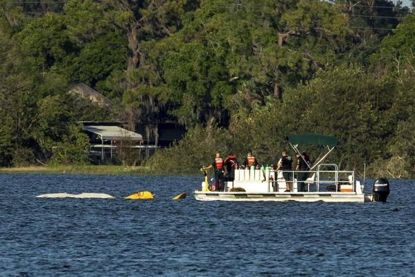 Polk County Sheriff Underwater Search & Recovery Team search the area around a partially submerged aircraft that crashed into Lake Hartridge after colliding with another aircraft on Tuesday, March 7, 2023, in Winter Haven, Fla. There has been one confirmed fatality and divers are searching for the other plane that sank. (Ernst Peters/The Ledger via AP)