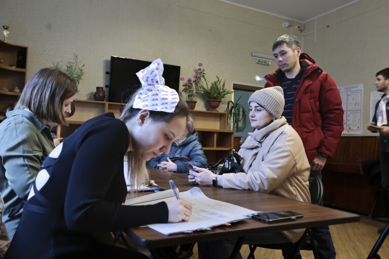 Los votantes esperan para emitir su voto en un colegio electoral durante las elecciones presidenciales en la ciudad portuaria de Vladivostok, en el Pacífico, a 6.418 kilómetros de distancia.  (3.566 millas) al este de Moscú, Rusia, viernes 15 de marzo de 2024. Los votantes en Rusia se dirigen a las urnas para una elección presidencial que seguramente extenderá el gobierno del presidente Vladimir Putin después de que reprimió la disidencia.  (foto AP)