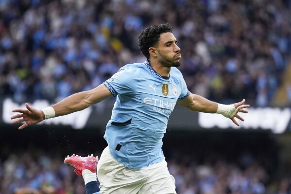Manchester City's Omar Marmoush celebrates after scoring his side's opening goal during the English Premier League soccer match between Manchester City and Bournemouth at the Etihad stadium in Manchester, England, Tuesday, May 20, 2025. (AP Photo/Dave Thompson)