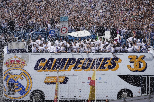 Real Madrid team players celebrate on an open-topped bus in Cibeles Square a week after clinching La Liga title in Madrid, Spain, Sunday, May 12, 2024. (AP Photo/Paul White)