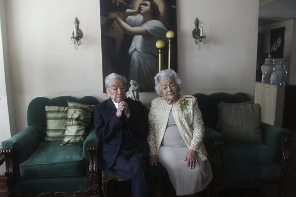 Married couple Julio Mora Tapia, 110, and Waldramina Quinteros, 104, both retired teachers, pose for a photo at their home in Quito, Ecuador, Friday, Aug. 28, 2020. The couple is recognized by the Guinness World Records as the oldest married couple in the world, because of their ages. They have been married for 79 years. (AP Photo/Dolores Ochoa)