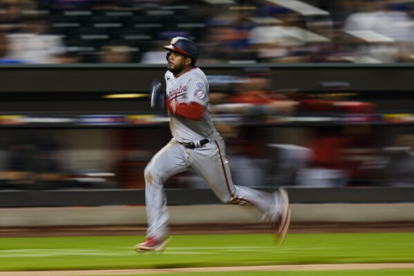 Washington Nationals' Jeimer Candelario runs to home plate to score on a single by Joey Meneses during the ninth inning of a baseball game against the New York Mets, Saturday, July 29, 2023, in New York. (AP Photo/Frank Franklin II)