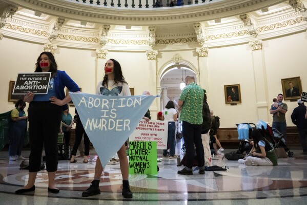 FILE - Sarah Zarr, left, from Students for Life of America, and Melanie Salazar, from the Progressive Anti-Abortion Uprising, stand inside the Texas State Capitol Rotunda to protest an International Women's Day Sit-In for Abortion Rights, Wednesday, March 8, 2023, in Austin, Texas. The state of abortion access in the U.S. remains in flux with an accusation against Planned Parenthood in Missouri and a plan to educate doctors headed to the governor in South Dakota. (Sara Diggins/Austin American-Statesman via AP, File)