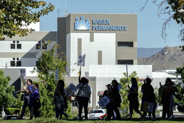 CAPTION CORRECTION CORRECTS NUMBER OF REPRESENTED HEALTH WORKERS: FILE - Healthcare workers picket outside Kaiser Permanente hospital during a nationwide strike, on Oct. 4, 2023, in Moreno Valley, Calif. Unions representing 85,000 health care workers have reached a tentative agreement with industry giant Kaiser Permanente following a strike over wages and staffing levels, the parties announced Friday, Oct. 13, 2023. Details of the agreement were not immediately released, but both sides said a full announcement was forthcoming. (Watchara Phomicinda/The Orange County Register via AP, File)