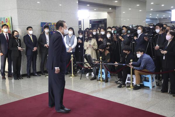 South Korean President Yoon Suk Yeol, foreground, speaks to journalists upon his arrival at the presidential office in Seoul, South Korea, Thursday, Nov. 10. 2022. Journalist organizations say South Korean President Yoon attacked press freedoms when his office banned a TV broadcaster's crew from the press pool traveling on his presidential plane this week for allegedly biased reporting. (Ahn Jung-hwan/Yonhap via AP)