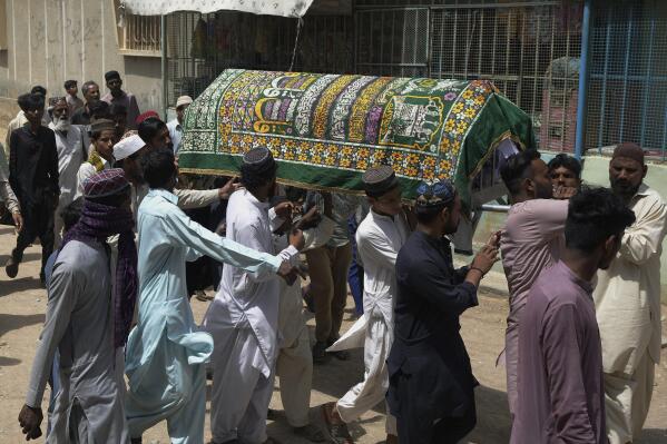 People carry coffins of a woman, who died in stampede, during her funeral, in Karachi, Pakistan, Saturday, April 1, 2023. Pakistani police arrested eight people in the southern port city of Karachi after a stampede killed several people at a Ramadan food and cash distribution point a day earlier. (AP Photo/Fareed Khan)