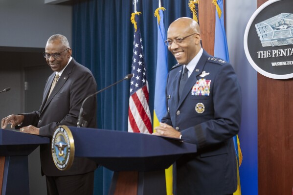 Defense Secretary Lloyd Austin, left, and Chairman of the Joint Chiefs of Staff Gen. CQ Brown Jr., share a laugh at the start of a press briefing on Friday, April 26, 2024 at the Pentagon in Washington. (AP Photo/Kevin Wolf)