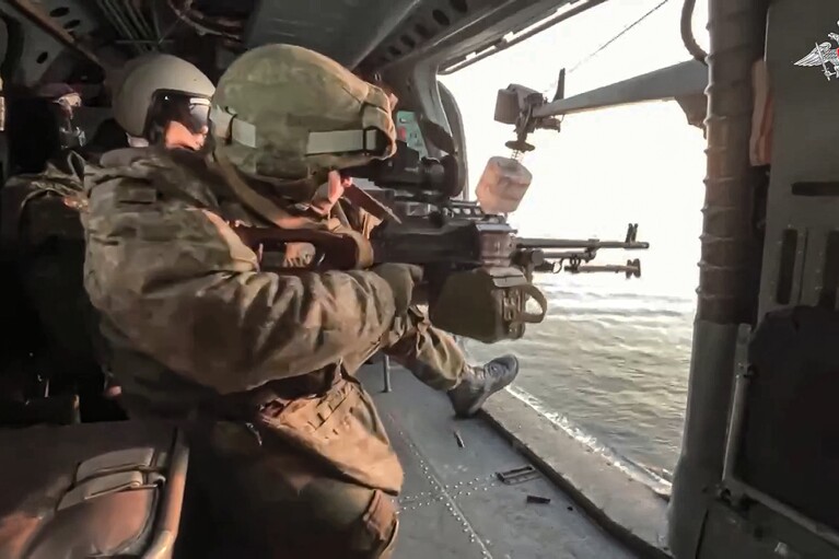 In this photo taken from video released by Russian Defense Ministry Press Service on Friday, Jan. 5, 2024, Russian soldiers fire from a Ka-27 helicopter during a patrol of the Black Sea.  (Russian Defense Ministry Press Service via AP, File)