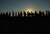 FILE - Migrants who crossed the Rio Grande and entered the U.S. from Mexico are lined up for processing by U.S. Customs and Border Protection, Sept. 23, 2023, in Eagle Pass, Texas. A divided Supreme Court on Tuesday, March 19, 2024, lifted a stay on a Texas law that gives police broad powers to arrest migrants suspected of crossing the border illegally, while a legal battle over immigration authority plays out. (AP Photo/Eric Gay, File)
