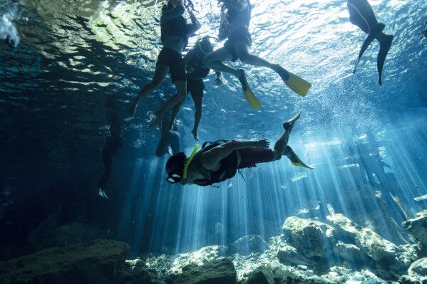 2024年3月9日，星期六，墨西哥卡门港郊区，游客们在“Dos Ojos”或“两只眼睛”中游泳。这些发光的天坑湖被称为cenotes，是墨西哥自然奇观之一的一部分：数千个地下洞穴、河流和湖泊组成的脆弱系统，蜿蜒于墨西哥南部尤卡坦半岛之下。（美联社照片/Rodrigo Abd）